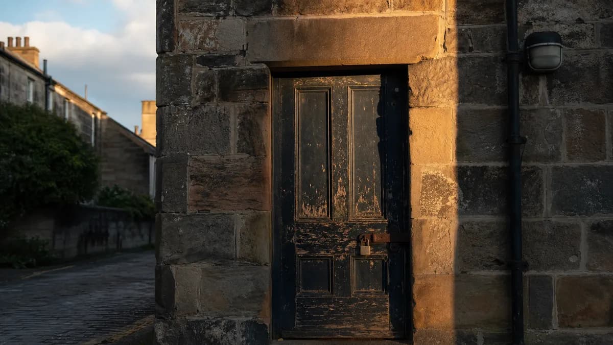 A locked back door of a small workshop on a Scottish high street at the end of the working day