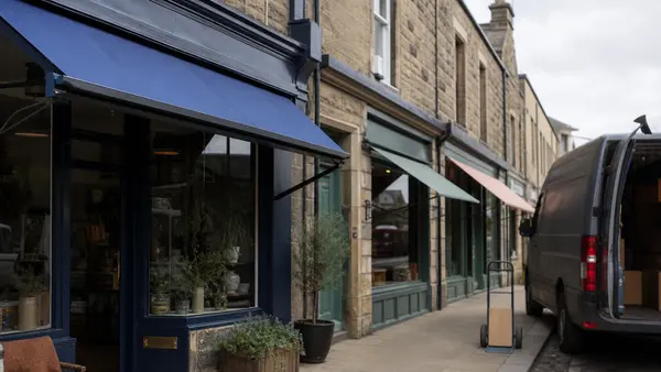 A quiet Scottish high street of small independent shops on a bright autumn morning.