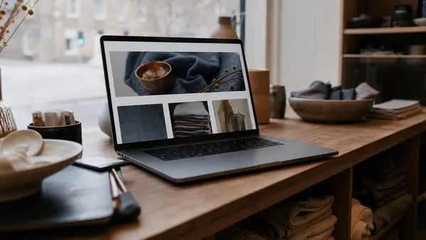 A laptop on a workbench in a small Scottish business showing a website design